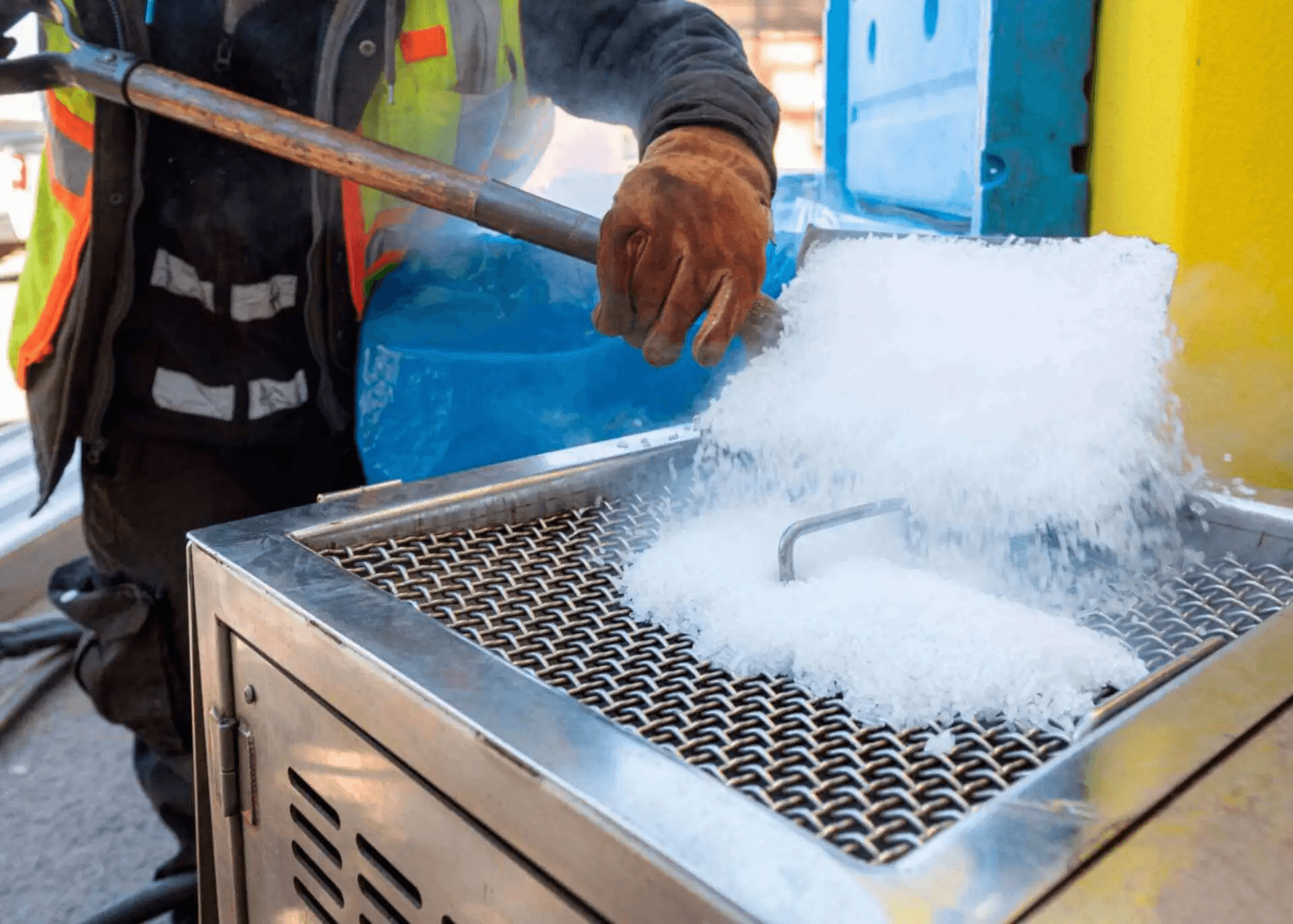 Technician removing zinc ash from galvanized steel with a dry-ice blaster at the outfeed