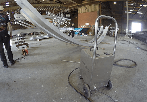 Large structural member cleaned on-line at the outfeed